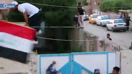 إزالة صورة نوري المالكي من قبل متظاهرين عراقيين اقتحمو مقر حزب الدعوة بالديوانية