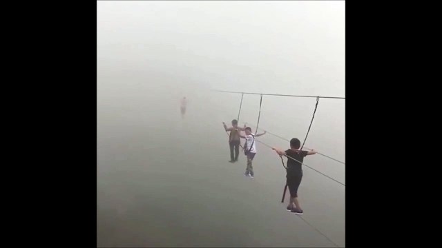 Ces touristes marchent sur un pont suspendu, perdu dans le brouillard... terrifiant