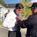 Un policier aide un jeune homme à nouer sa cravate et c'est adorable
