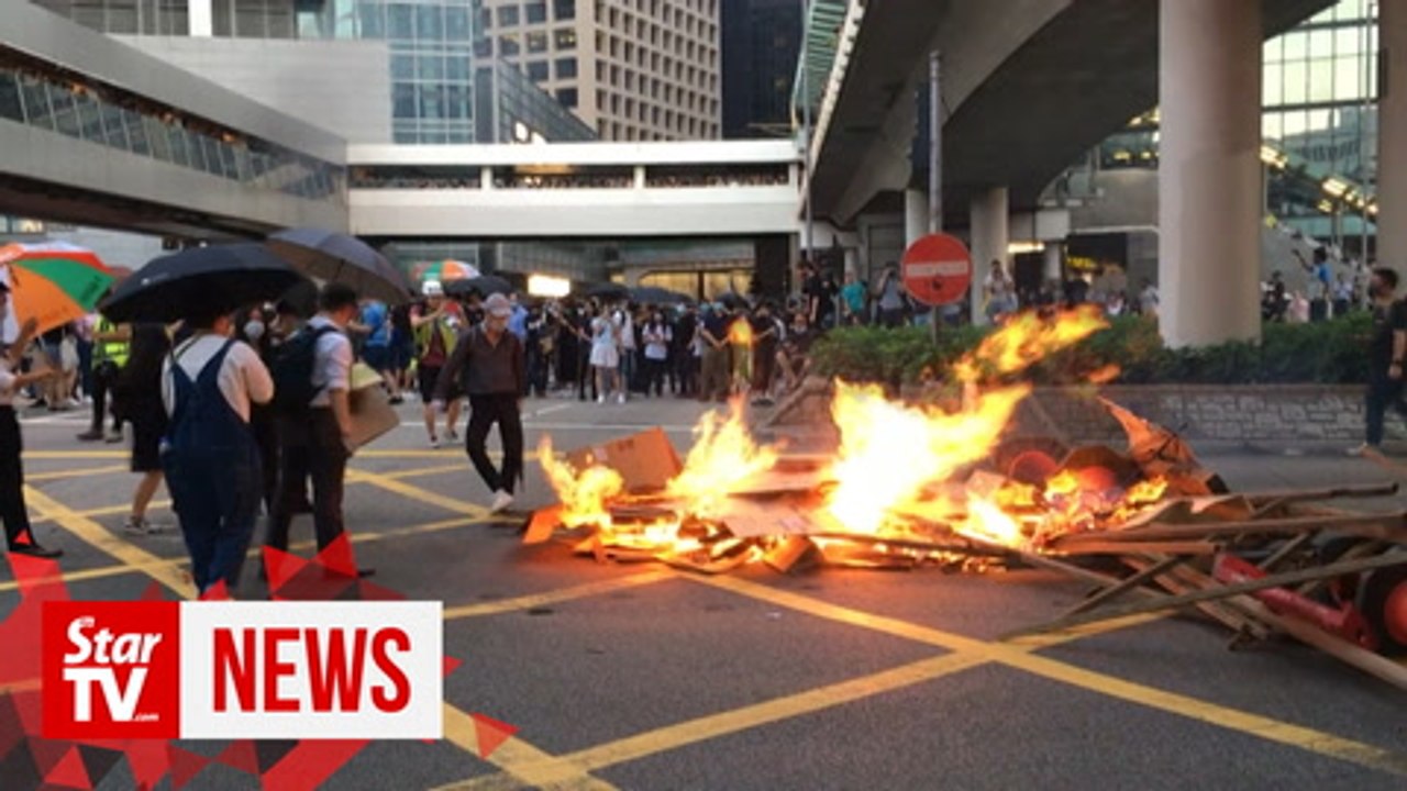 Protesters set fire to China anniversary banner in Hong Kong