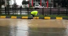 Trafik polisi, ayakkabılarını çıkararak aşırı yağış nedeniyle tıkanan mazgalları temizledi