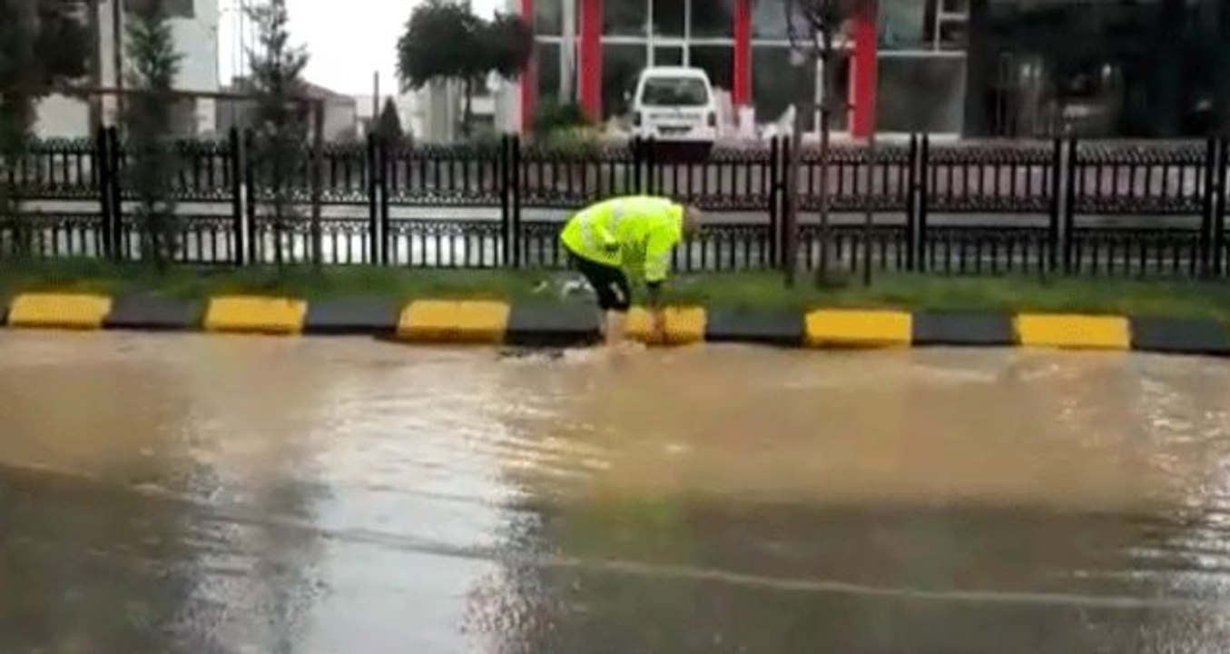 Trafik polisi, ayakkabılarını çıkararak aşırı yağış nedeniyle tıkanan mazgalları temizledi