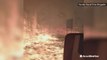 Firetruck drives through road surrounded by raging wildfire