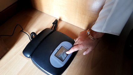 Une conseillère de probation présente le boitier du bracelet électronique