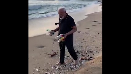 India Prime Minister Narendra Modi helps clear beach of rubbish