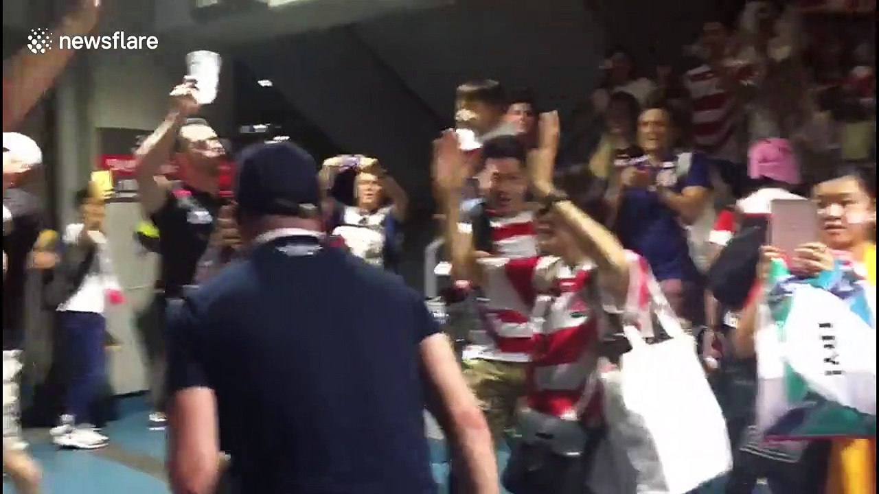 Fans celebrate Japan's historic victory over Scotland at Yokohama stadium