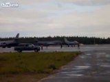Un avion de chasse F-16 se fait retourner par la puissance d'un plus gros avion au décollage