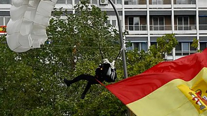 Un parachutiste se coince dans un lampadaire pendant un défilé militaire