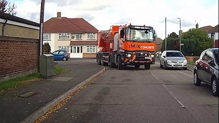 Driver of cement mixer lorry with no wing mirror uses phone to reverse down UK road
