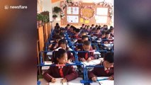 Chinese school installs bars over desks to help correct pupils' posture when handwriting