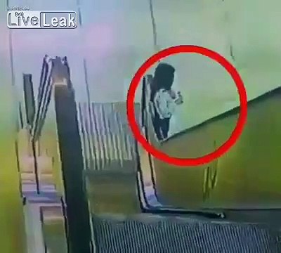 Sa veste se coince dans la rampe de l'escalator mais elle va avoir beaucoup de chance