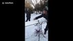 Good catch! Man throws a glass of beer using a snowboard and his friend successfully catches it