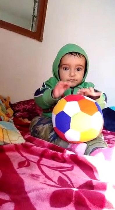 Cute baby is playing with bollybol.