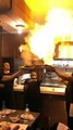 Des serveurs flambent des saganákis dans un restaurant grec
