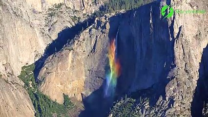 Un magnifique arc-en-ciel se forme sur une chute d'eau