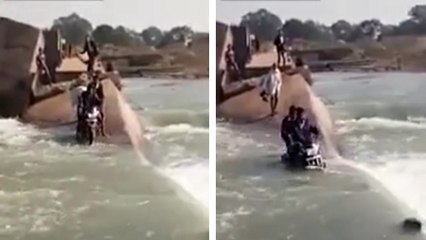 Un homme traverse une rivière en moto