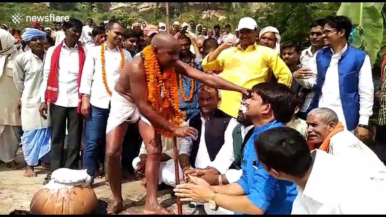 Hindu mystic bathes with boiling milk and throws it onto his disciples