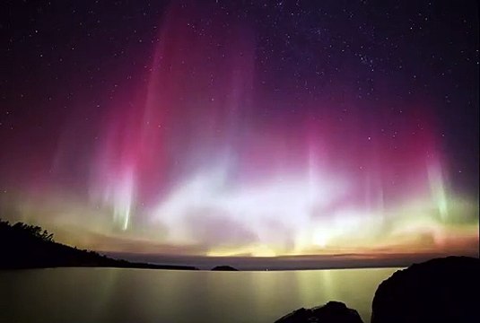 Il filme de magnifiques Aurores Boréales au dessus d'un lac dans le Michigan