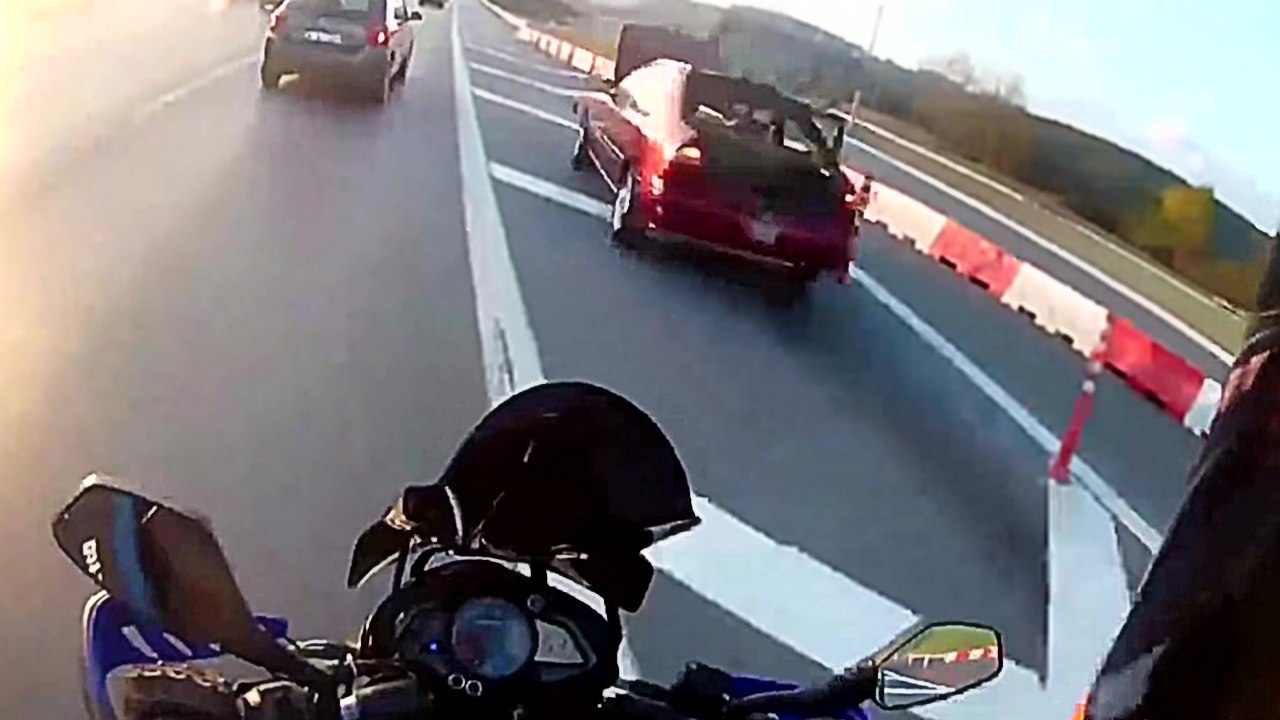 Un motard qui roule sur la bande d'arrêt d'urge...