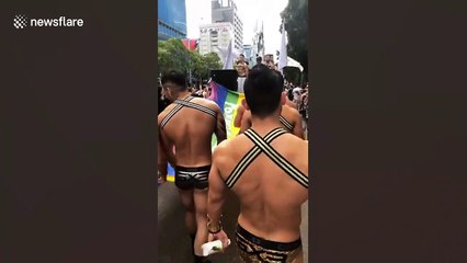 Cheeky grandmother films muscle-bound man's bottom at LGBT march in Taiwan