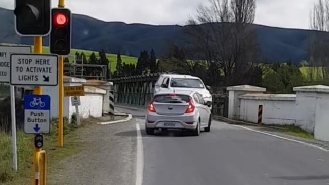 Instant karma pour un automobiliste qui grille un feu rouge pour passer sur un pont à une voie