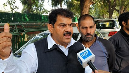Jagdish Sharma distributes sweets outside the residence of Sonia Gandhi