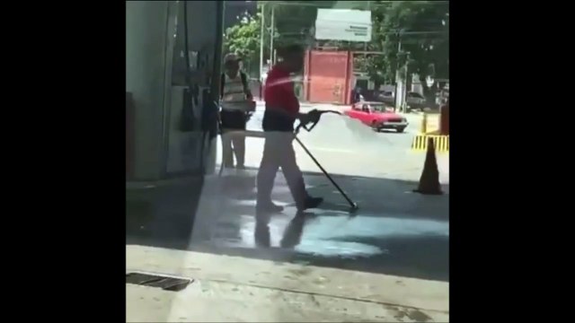 Cet employé de station service utilise la pompe à essence comme jet d'eau...
