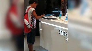 Niño hace la tarea de clase en una tablet de un centro comercial
