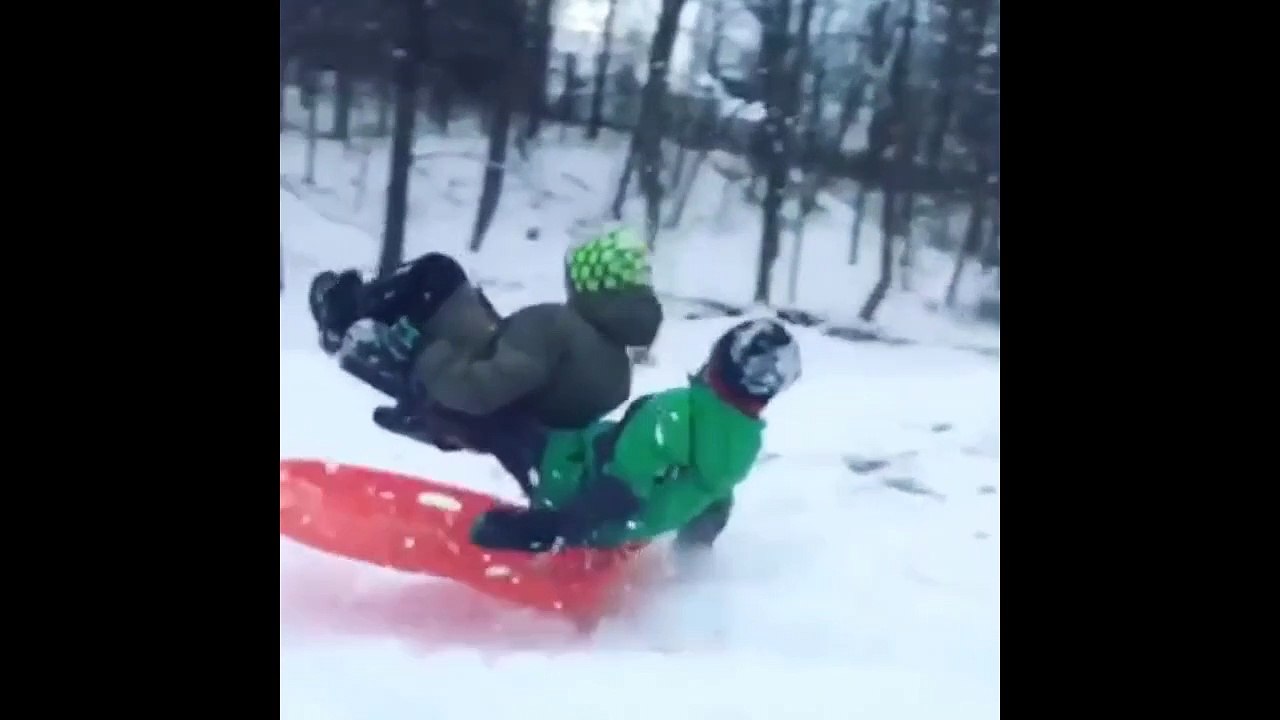 Two Kids On A Sled Jump A Ramp