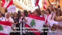 Des manifestants cognent sur des murs devant le Parlement libanais
