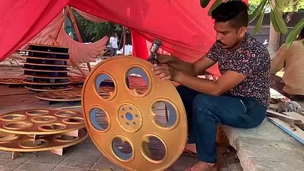 Large cutouts of film reel models get spray painted in gold and jewel blue ahead of IFFI 2019 in Goa.