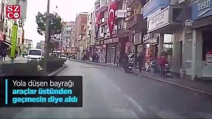 Yola düşen bayrağı araçlar üstünden geçmesin diye aldı