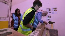 Corbyn shows off his bricklaying skills during college visit