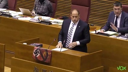El diputado de Vox en Las Cortes Valencianas, David García, mostrando los símbolos totalitarios del comunismo y el nazismo tachados.