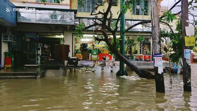 Residents wade through flooded streets after Typhoon Kammuri lashed the Philippines
