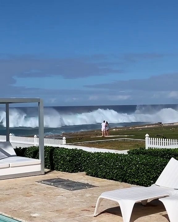 Un couple pris par surprise par une grosse vague sur la plage de la République Dominicaine