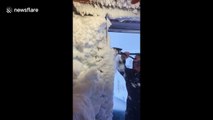 'Scraping the house as one does!' Man shovels thick layer of snow from his home after wild blizzard hits northern Iceland