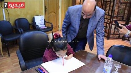 محافظ أسوان يكافئ طفلة مصابة بضمور لموهبتها فى الرسم بـ"فمها"