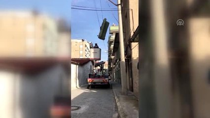 Çatı katından atılan üçlü koltuk, elektrik teline takıldı