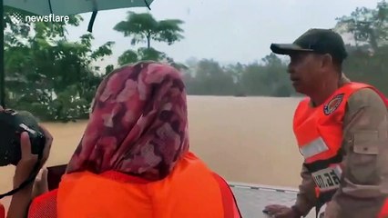 Relief workers search through flooded homes in southern Thailand after heavy rains