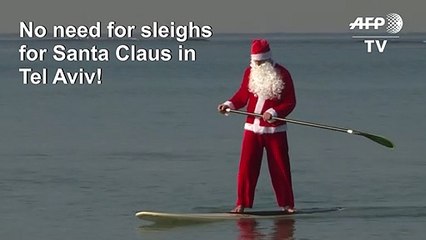 Santa Claus floats to Tel Aviv on his standup paddleboard