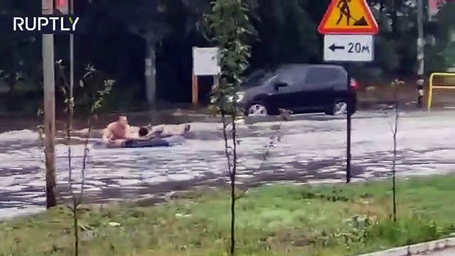 Estos rusos se divierten en calles inundadas por la lluvia con un colchón como balsa