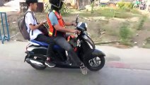 Dog rides with motorcycle taxi in matching uniform