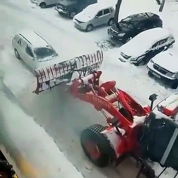 Une voiture mal garée obtient une punition de la part d'un conducteur d'une déneigeuse