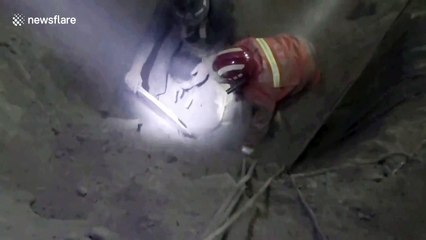 Firefighters rescue worker buried in eight-metre-deep concrete storage tank after he accidentally fell