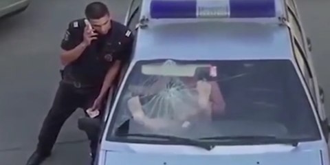 La rubia rusa medio desnuda rompe a patadas el cristal del parabrisas al coche de la Policía