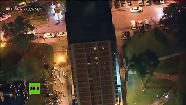 Un hombre escapa de un edificio en llamas descendiendo por las ventanas