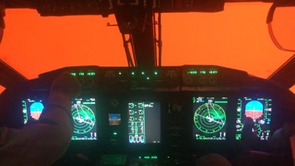 Pilot cockpit view shrouded in orange glow from Australia's bush fires
