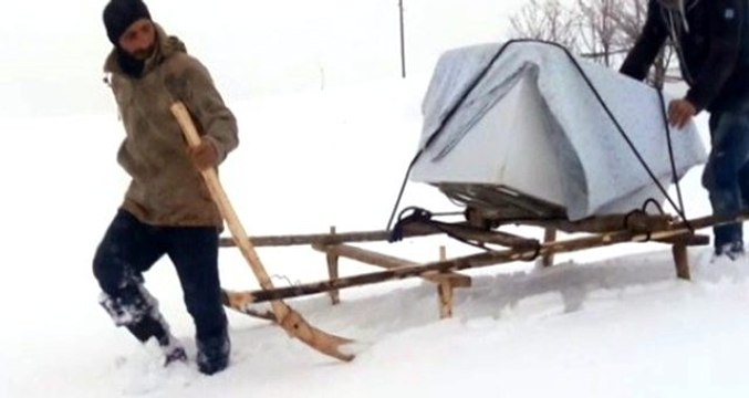 Kar yağışının esir aldığı kentte, arızalı bulaşık makinesi kızakla taşındı