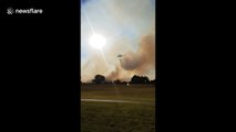 Waterbombing helicopter douses flames during bushfire in Forrestfield, Perth